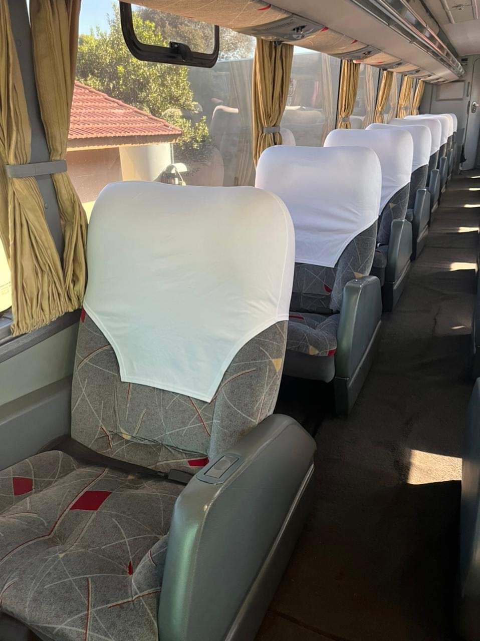 Corredor e poltronas no interior do ônibus